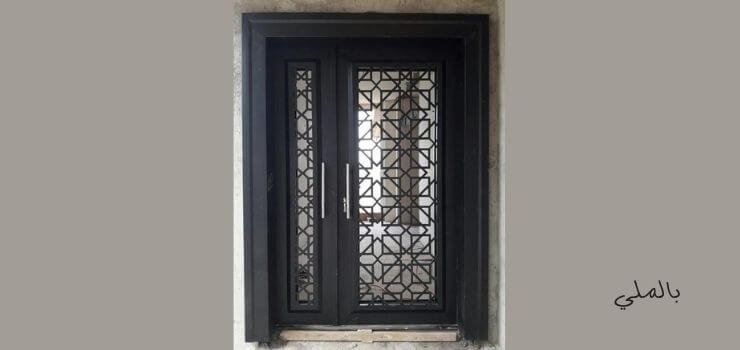 باب حديد مودرن اسود وذو زخارف بسيطة.